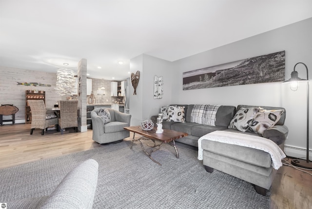 living area featuring a baseboard heating unit and wood finished floors