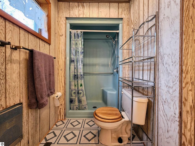 full bathroom featuring tile patterned floors, toilet, and a shower stall