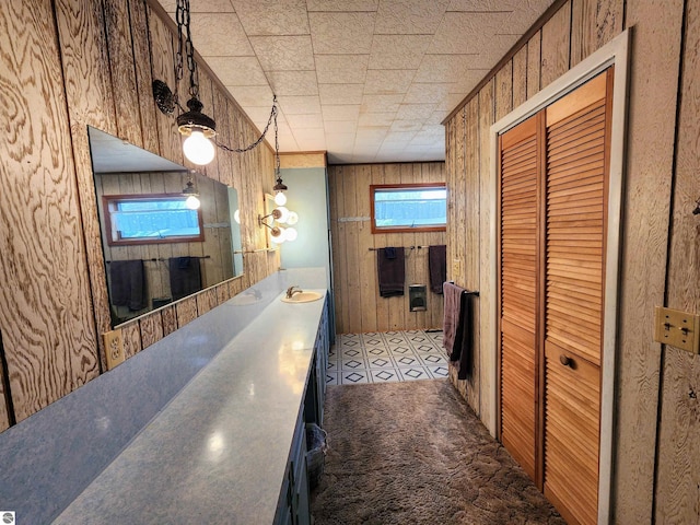 corridor featuring wooden walls and a sink