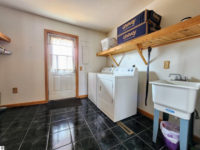 laundry area featuring dark tile patterned flooring, baseboards, laundry area, and washing machine and dryer