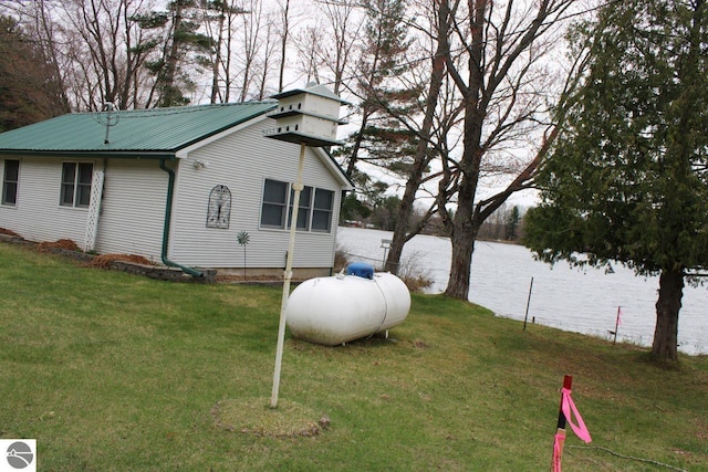 view of side of home featuring a yard and metal roof