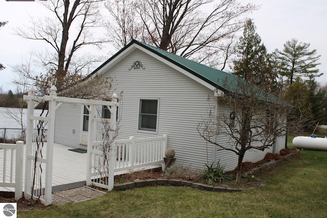 view of property exterior with a yard, fence, and a wooden deck