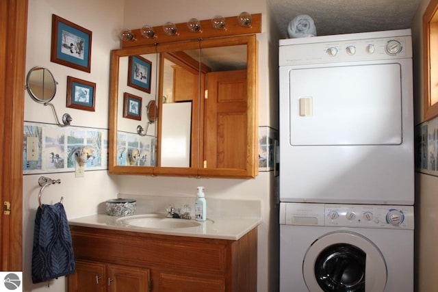 washroom with a sink, laundry area, and stacked washer / dryer