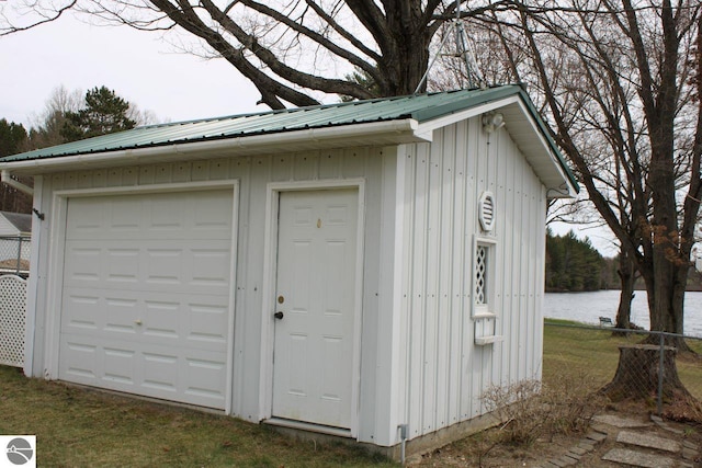 view of shed with a water view and fence