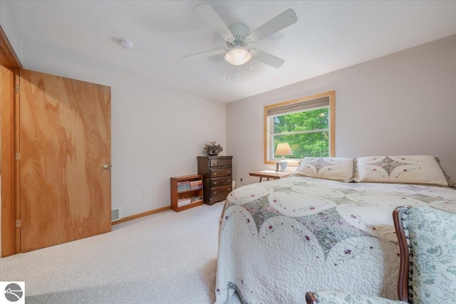 bedroom with baseboards, ceiling fan, visible vents, and light carpet