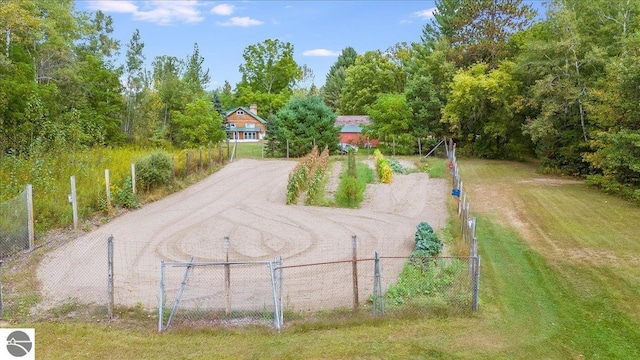 surrounding community featuring a yard, fence, and dirt driveway