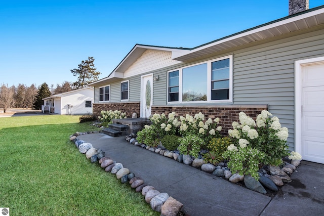 2280 NW Tamara Rd, Kalkaska, MI 49646 - view of side of home featuring a lawn and brick siding