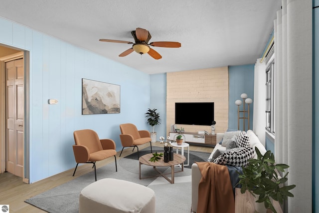 2280 NW Tamara Rd, Kalkaska, MI 49646 - living room with a ceiling fan, a textured ceiling, and light wood-type flooring