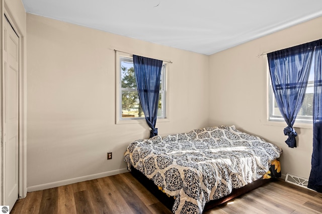 2280 NW Tamara Rd, Kalkaska, MI 49646 - bedroom with baseboards, wood finished floors, and visible vents