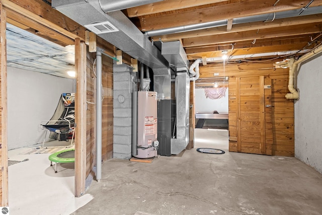 2280 NW Tamara Rd, Kalkaska, MI 49646 - unfinished below grade area with heating unit, visible vents, and gas water heater