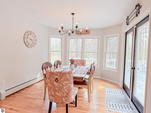 dining area featuring baseboards, baseboard heating, light wood finished floors, and a chandelier
