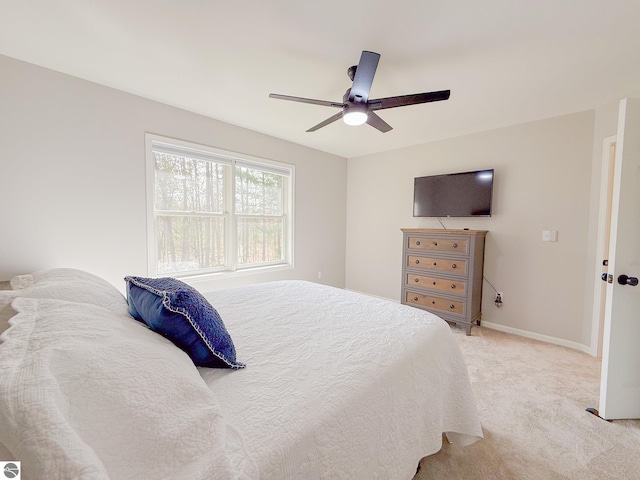 bedroom with ceiling fan, light colored carpet, and baseboards