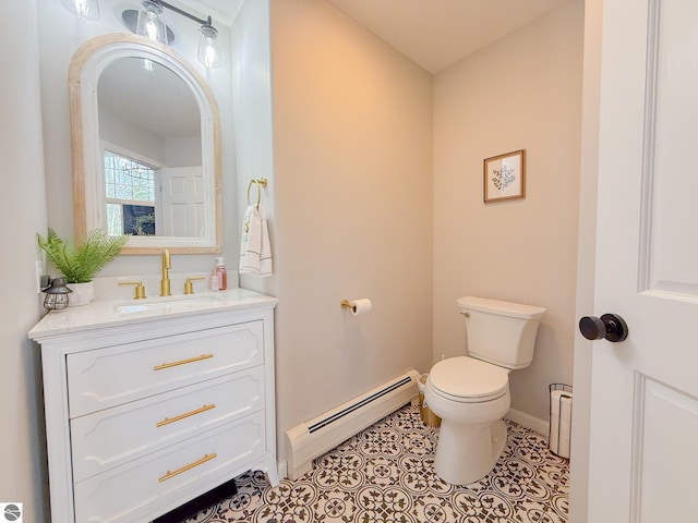 half bathroom with vanity, tile patterned flooring, toilet, baseboards, and a baseboard heating unit