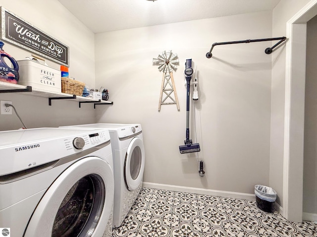 clothes washing area with separate washer and dryer, laundry area, and baseboards