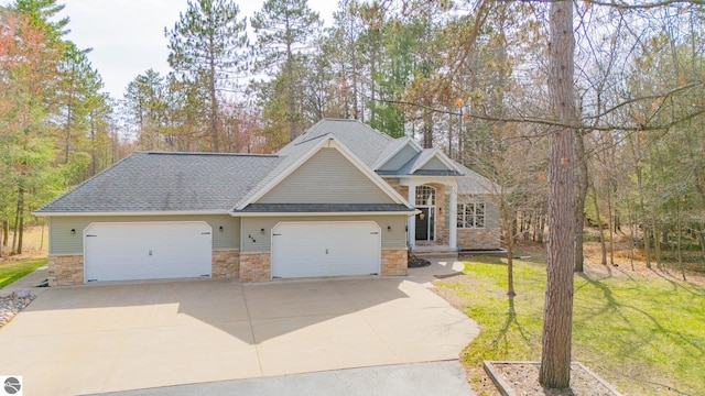 view of front of house with a front yard, driveway, and stone siding