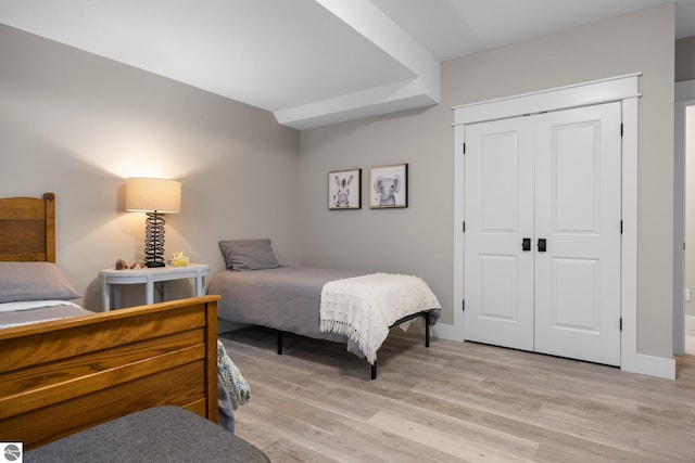 bedroom featuring baseboards, a closet, and light wood-type flooring