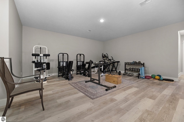 workout room with baseboards, recessed lighting, light wood finished floors, and visible vents