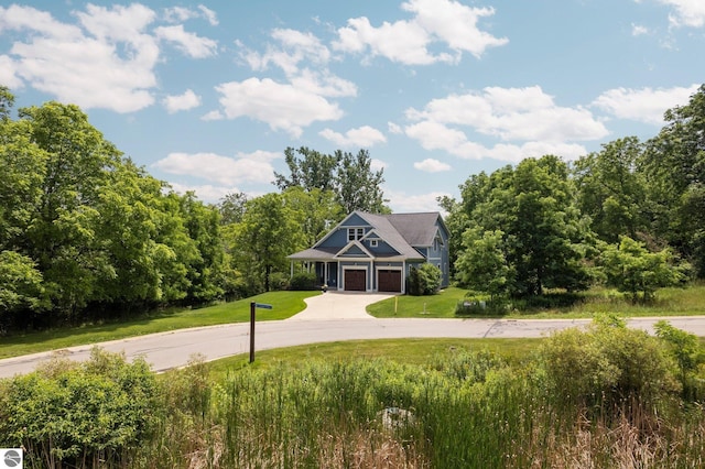 craftsman house featuring curved driveway, a garage, and a front lawn