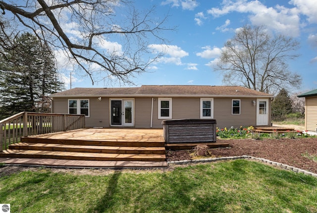 back of property featuring a lawn, a hot tub, and a wooden deck