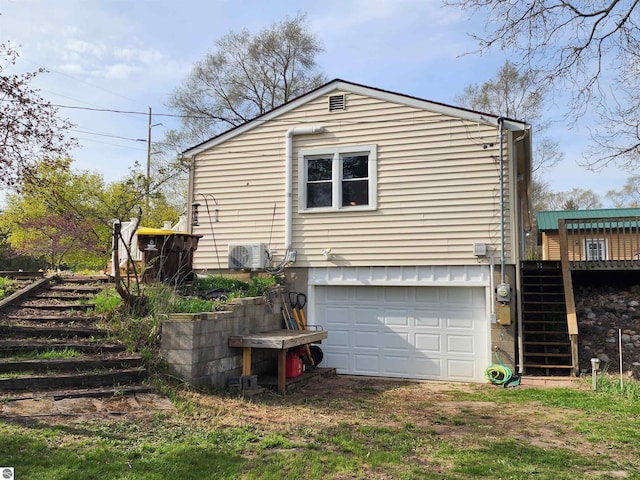 view of home's exterior featuring stairs, a garage, driveway, and a deck