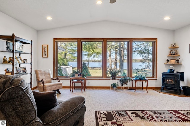 5449 E Shore Dr NE, Kalkaska, MI 49646 - living room with a wood stove, lofted ceiling, baseboards, recessed lighting, and a water view