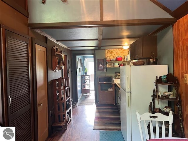 kitchen featuring freestanding refrigerator, stainless steel microwave, and dark wood finished floors