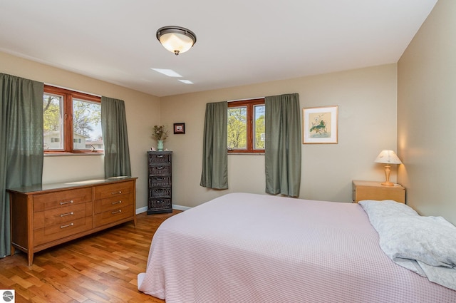 bedroom featuring light wood-style floors and baseboards