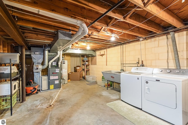 unfinished basement featuring independent washer and dryer, heating unit, a sink, and gas water heater