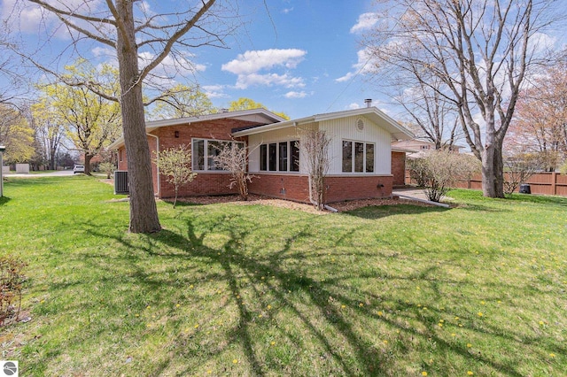 view of side of home with a lawn, cooling unit, and brick siding