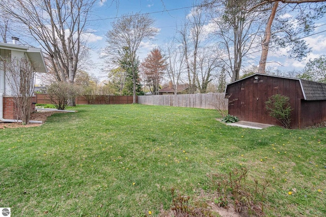 view of yard featuring a fenced backyard, an outdoor structure, and a shed
