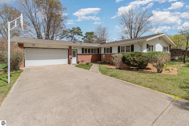 ranch-style home featuring a front yard, a chimney, brick siding, concrete driveway, and an attached garage