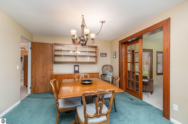 carpeted dining room featuring baseboards and a notable chandelier