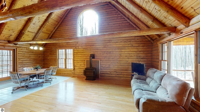 living room featuring a wood stove, wood ceiling, and beam ceiling