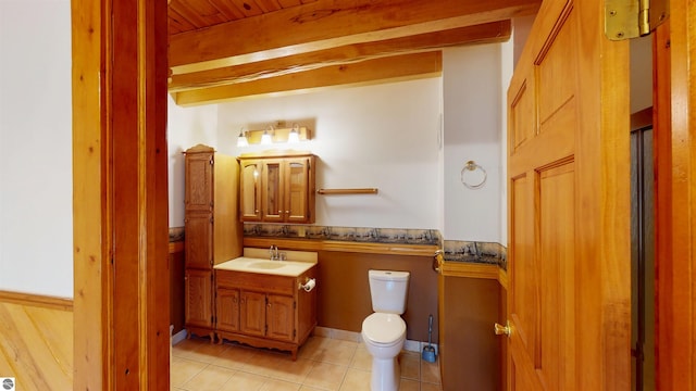 half bath featuring vanity, tile patterned flooring, and toilet