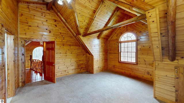 additional living space with wooden walls, wood ceiling, lofted ceiling with beams, and carpet floors