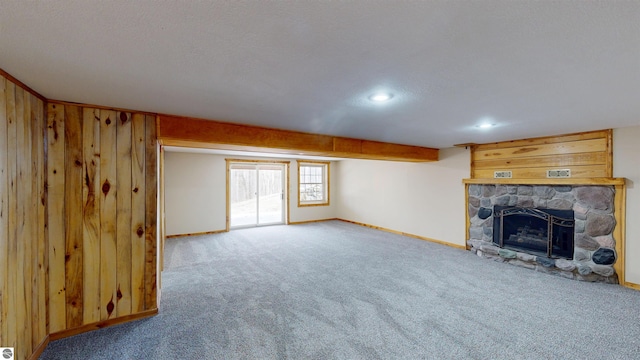 unfurnished living room with carpet flooring, a fireplace, a textured ceiling, recessed lighting, and baseboards
