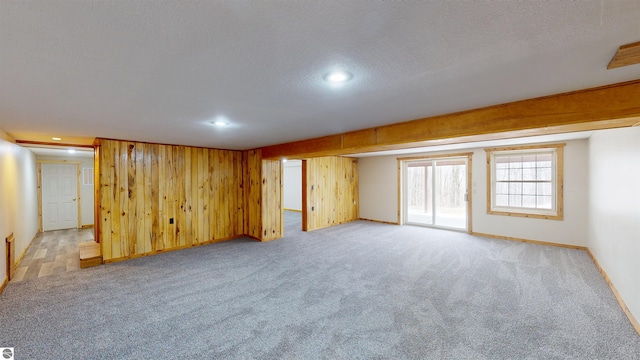 unfurnished room with recessed lighting, a textured ceiling, baseboards, and light carpet
