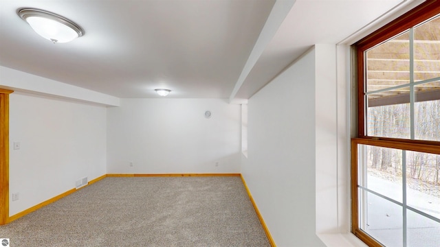 basement with carpet floors, baseboards, and visible vents
