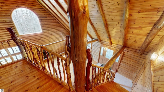 stairs featuring wood ceiling, lofted ceiling with beams, log walls, and hardwood / wood-style flooring