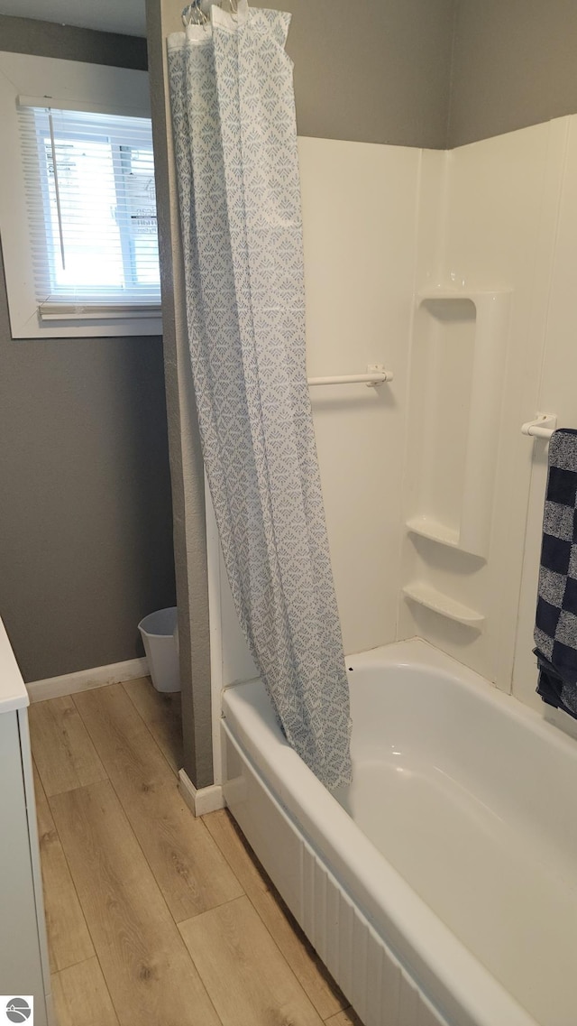 full bathroom featuring wood finished floors and shower / bath combination with curtain
