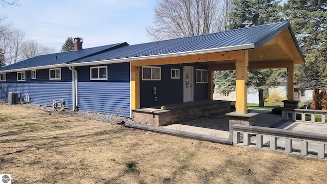 view of front of property with central AC unit and metal roof