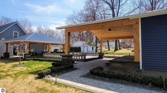 exterior space featuring a patio, a gazebo, an outdoor structure, and a storage unit