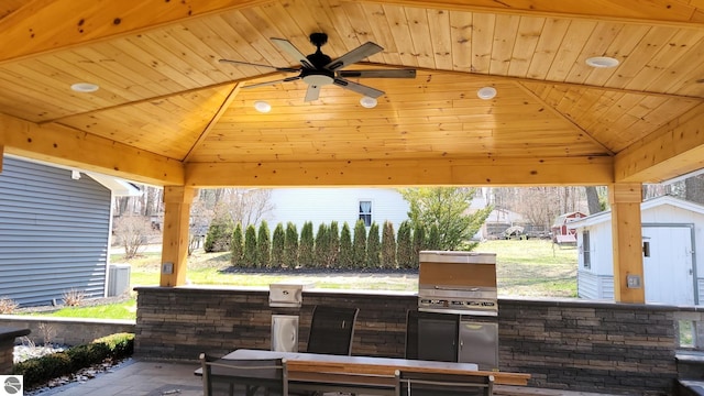 view of patio with a storage unit, a gazebo, area for grilling, an outbuilding, and a ceiling fan