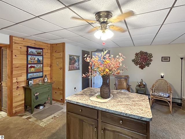 interior space featuring a ceiling fan, a drop ceiling, and baseboard heating