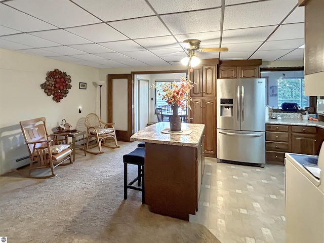 kitchen featuring light countertops, stainless steel fridge with ice dispenser, and a paneled ceiling