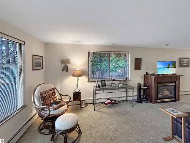 interior space with a glass covered fireplace, carpet, and a baseboard radiator