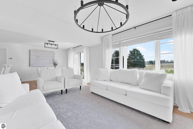 living area with wood finished floors and a notable chandelier