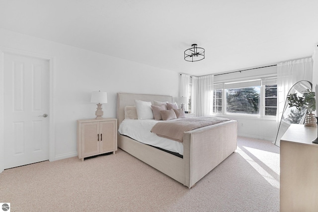 bedroom featuring baseboards and light carpet