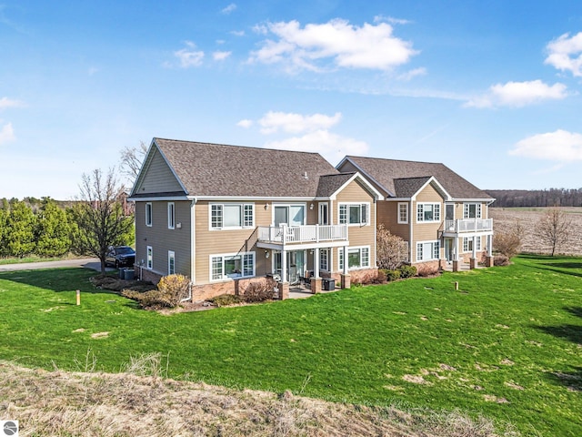 rear view of house featuring a yard, a patio, a balcony, and a deck