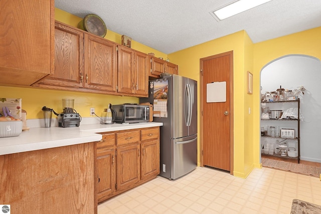 9916 S M-37, Buckley, MI 49620 - kitchen with light floors, light countertops, a textured ceiling, brown cabinets, and stainless steel appliances